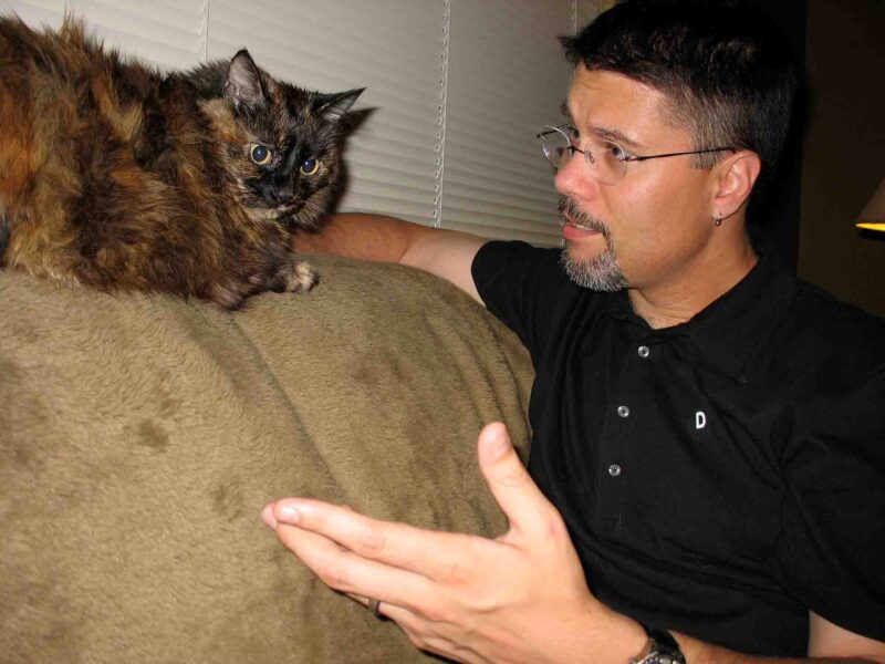 a man and his cat talking on the couch