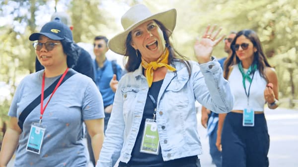 woman in cowboy hat waving and smiling