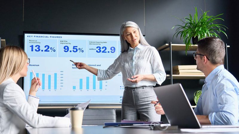 A Black woman leads a presentation showing key statistics.