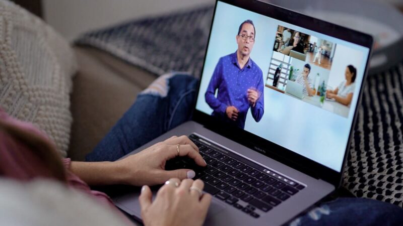 A person watches a virtual presentation on their laptop.