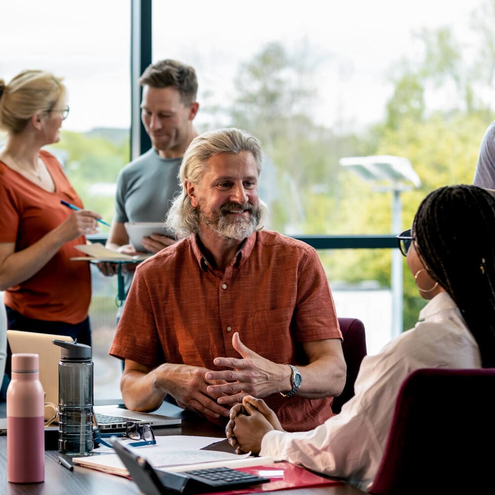 A group of people chatting during a work event.