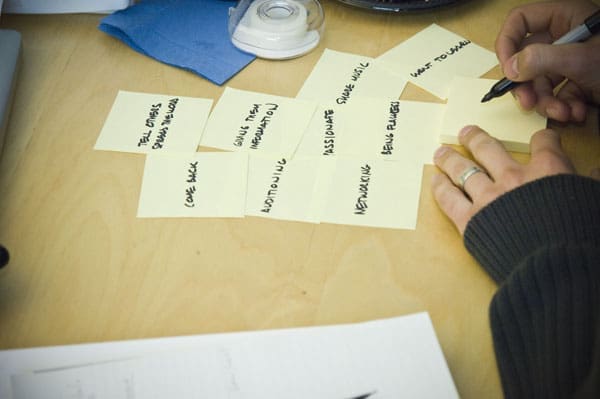 Person writing on sticky notes during a slideology workshop