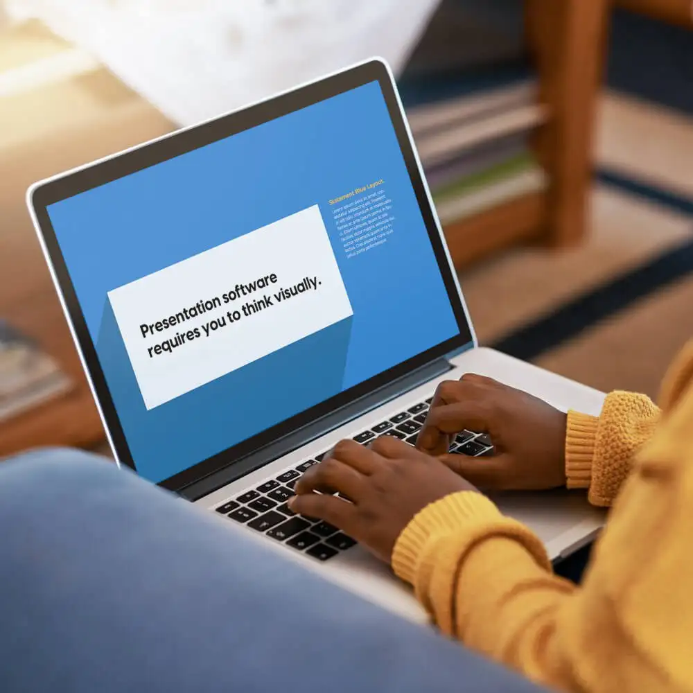 A Black person types out copy for a slide on their laptop.