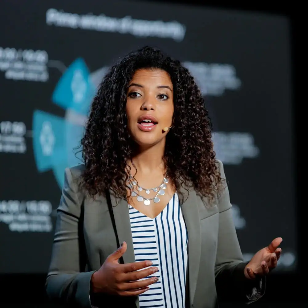 A Black woman leads a talk during a presentation at a conference.